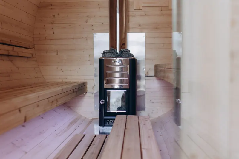 Wide view of the sauna interior with the stove and benches